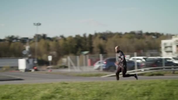 Handschwenkbild Eines Schwarz Gekleideten Mannes Der Einem Stadtgebiet Schnell Läuft — Stockvideo