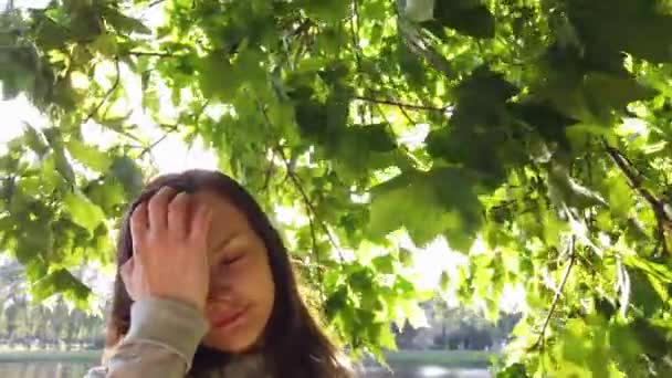 Dziewczyna Ręką Włosach Zwolnionym Tempie Stojąca Parku Światłem Słonecznym Przez — Wideo stockowe