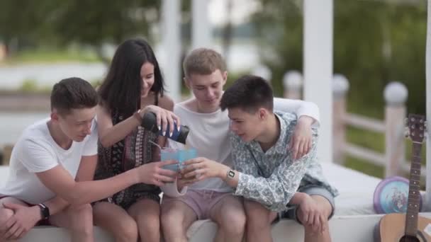 Glücklich Teenager Mädchen Sharing Sie Drink Mit Sie Boy Friends — Stockvideo