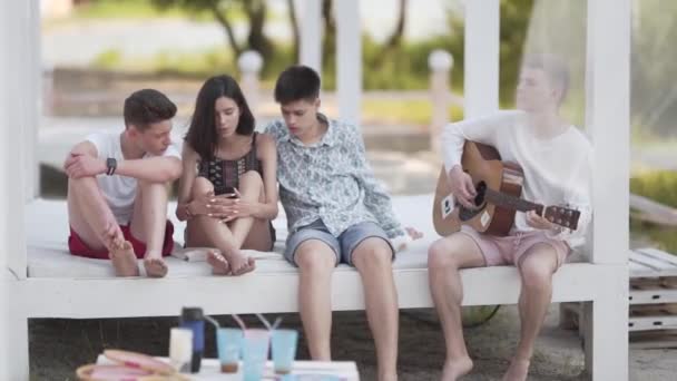 Група Міських Підлітків Літній Час Під Балдахіном Граючи Гітару Співаючи — стокове відео