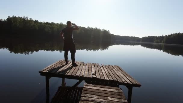Man Looks Horizon Wooden Boat Dock Sunny Summer Day Slow — Video