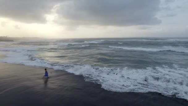 海の波と熱帯の楽園の砂のビーチでの生活を祝う青いドレスの女性の空中夕日 — ストック動画