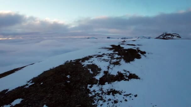 Aerial Flyover Mountaineer Standing Edge Snow Covered Cliff Revealing Cloud — Stockvideo