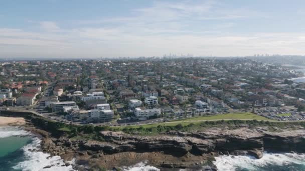 Maroubra Beachにあるシドニーの東部郊外にあるウォーターフロントのプロパティと近所の家 空中ドローンは ビーチ 海岸沿いの散歩 崖や街のスカイラインと道路に向かって飛んで逆に — ストック動画