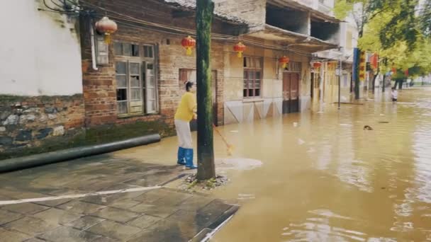 Ασιάτισσα Γυναίκα Σαρώνει Πλημμυρισμένο Νερό Στους Δρόμους Της Γκουιλίν Κίνα — Αρχείο Βίντεο