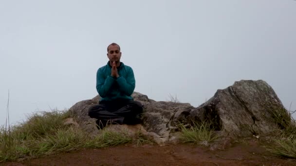 Hombre Meditando Roca Montaña Con Fondo Niebla Blanca Desde Ángulo — Vídeo de stock