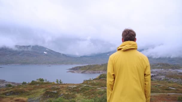 Драматичний Норвезький Озерний Ландшафт Горах Людина Жовтому Плащі Дивлячись Вид — стокове відео