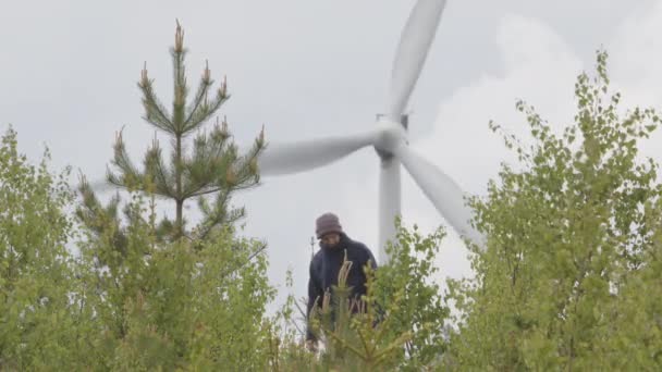 Mężczyzna Idzie Dół Wzgórza Przed Turbiną Wiatrową Szwecji Jasno Pochmurnie — Wideo stockowe