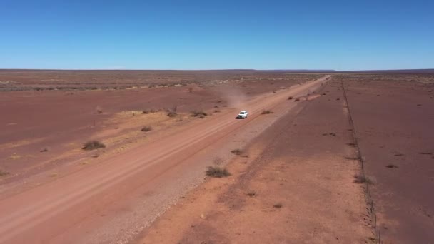 一辆4X4越野车在纳米比亚的一条长路上行驶 这条路完全是空旷的 直到地平线你才能看到任何东西 路上的沙子是红色的 很容易被搅拌起来 由无人机拍摄 — 图库视频影像