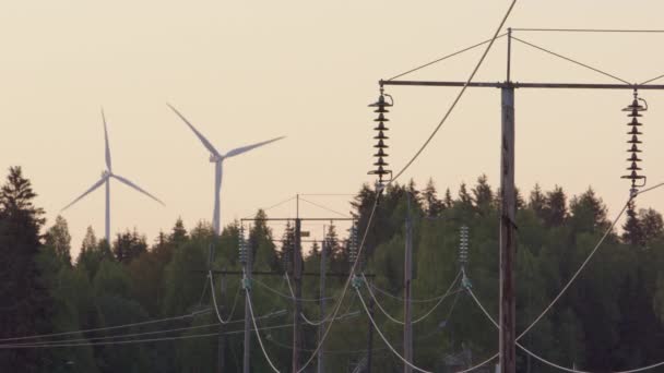 Vindturbiner Snurrar Bakom Elkablar — Stockvideo