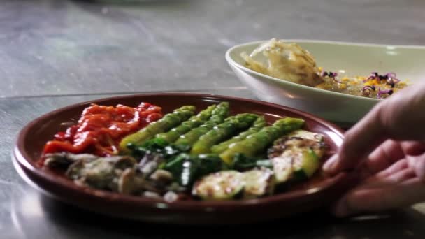 Großaufnahme Von Spargelsalat Und Gebratenem Fisch Über Einer Metallischen Küchentheke — Stockvideo