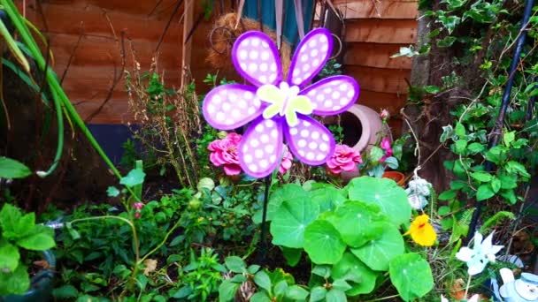 Kolorowy Wirujący Dziecięcy Wiatrak Motylkowy Wiejący Wietrze Wśród Rozkwitających Kwiatów — Wideo stockowe