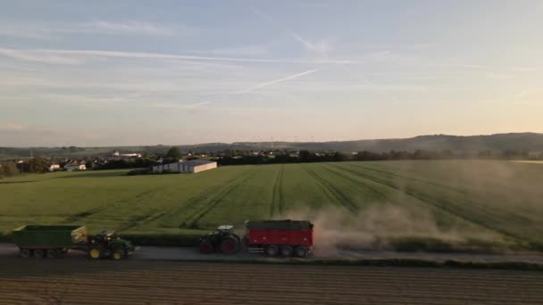 Tractores Agrícolas Tirando Remolques Hermosa Vista Los Campos Montaña Aerogeneradores — Vídeo de stock