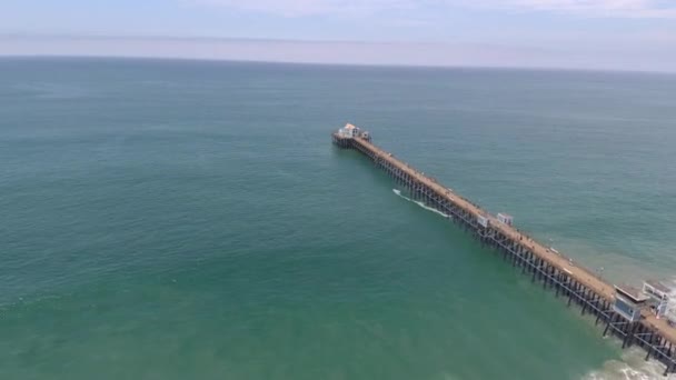 People Walking Beach Pier Sunny Day Water Waves Aerial Drone — стокове відео