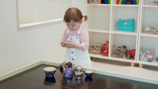 Цікава Маленька Дівчинка Розділяє Ляльку Матрьошки Столі Дитячому Кафе Закрий — стокове відео