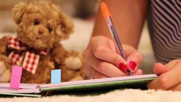 Jovem Está Escrever Seu Diário Pappy Urso Brinquedo Fundo — Vídeo de Stock