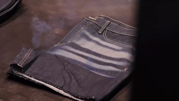 牛仔裤商店在工厂里被激光弄得垂头丧气 烟雾弥漫的近景 — 图库视频影像