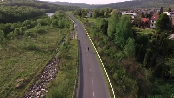 Man Rolschaatsen Lege Weg Zonsondergang Filmische Luchtfoto — Stockvideo