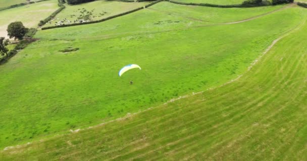 パラグライダーの空中撮影は 背後にある英語の田舎と丘を離陸 — ストック動画