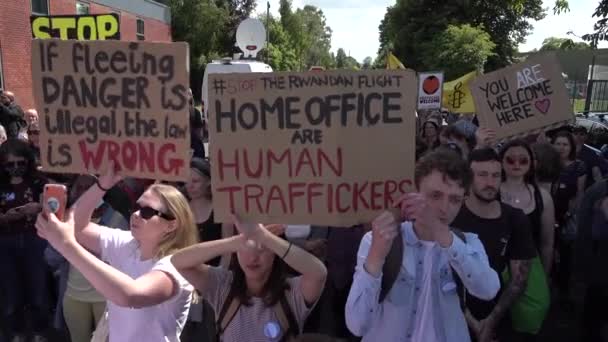抗议者高举各种手工制作的纸板标语牌 高呼抗议第一次飞往卢旺达驱逐被政府视为非法移民的航班 — 图库视频影像