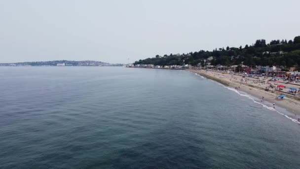 Drone Strzelił Kontrastując Spokojne Wody Puget Sound Ruchliwymi Piaskami Alki — Wideo stockowe