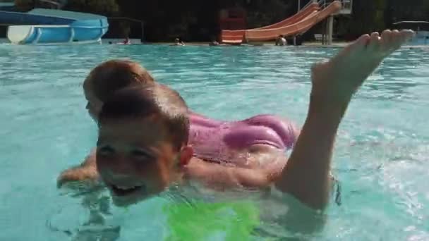一个男孩同一个女孩在游泳池边的水里玩耍 充满欢笑和轻松的游戏 — 图库视频影像