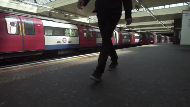 Niskokątne Ujęcie Pociągu Przylatującego Stację Finchley Road Jako Biały Mężczyzna — Wideo stockowe