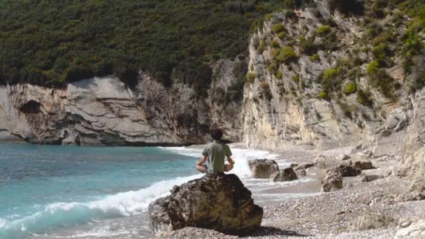 Solo Traveler Meditating Rock Sea Shore Surrounded Dense Green Cliffs — Stock Video