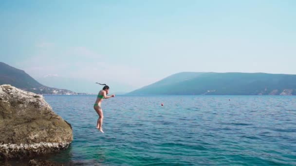 Adult Woman Jumping Rock Sea Water Clear Day Static Slow — Vídeo de stock