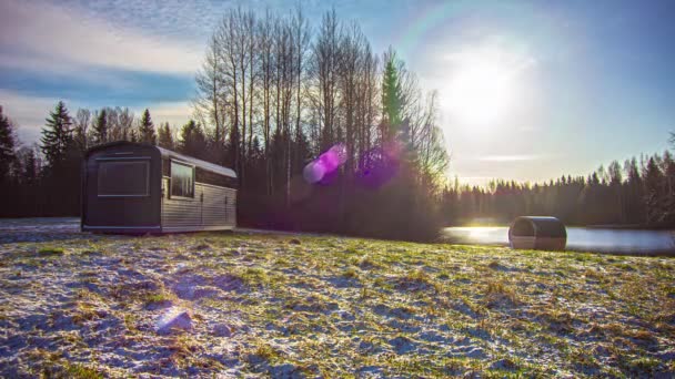 在多云的冬日里 一个长方形小木屋和一个桶桑拿的时间流逝 雪融化表明春天已经来到农村 背景中的普里斯汀湖 — 图库视频影像