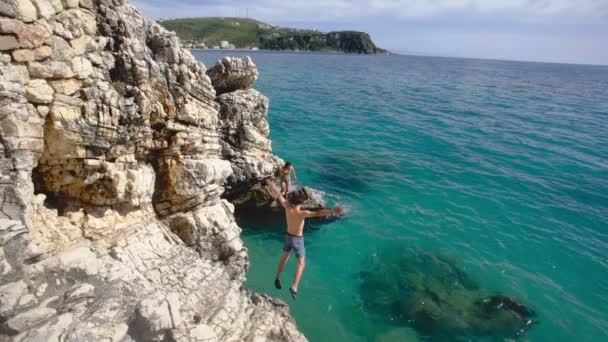Slow Motion Shot Couple Friends Jumping Rocky Cliff Turquoise Sea — ストック動画