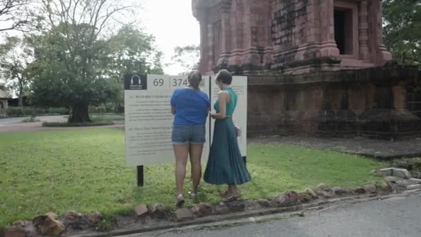 Dos Turistas Femeninas Leyendo Tablón Información Junto Antiguo Santuario Antiguo — Vídeos de Stock