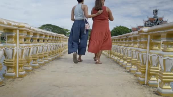 两名女游客在古城公园的金桥上漫步 泰国木兰 低角度射击 — 图库视频影像