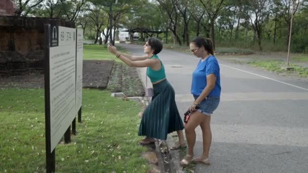 Dos Turistas Pie Tomando Fotos Las Informaciones Importantes Del Tablón — Vídeo de stock