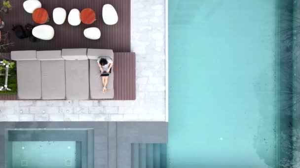 Remote Worker Leisurely Sitting Pool Lounge While Working His Laptop — Vídeo de Stock