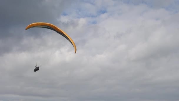 Paraglide Pilotu Bulutlu Gökyüzünde Tek Başına Zarif Dönüşler Gerçekleştiriyor — Stok video