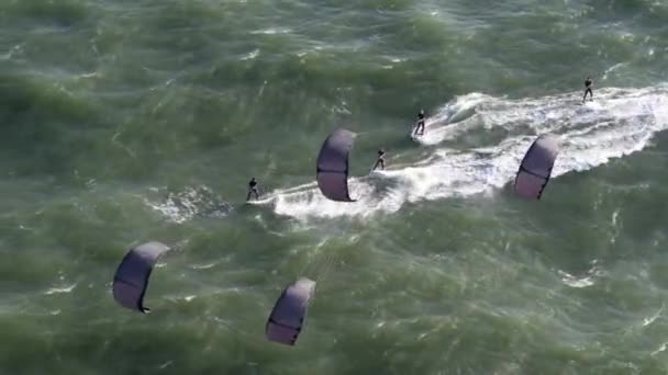 Vista Aérea Cuatro Surfistas Cometas Que Corren Través Del Mar — Vídeo de stock