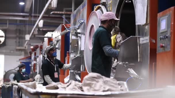 Trabajadores Masculinos Vaciando Grandes Secadoras Ropa Industriales Fábrica Pakistán Moción — Vídeo de stock