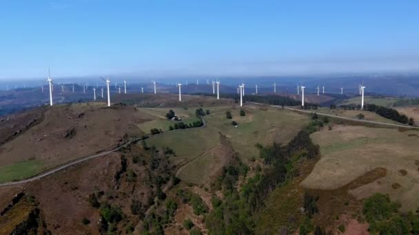 風力タービンを備えた風力発電所は 晴れた日の午後に緑の木々の森と山の中でヘリックスを動かす ドローン前方に移動ショット ルーゴ ガリシア スペイン — ストック動画