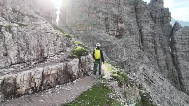 ドロマイトの登山用具を持つ女性登山家が道を歩く — ストック動画