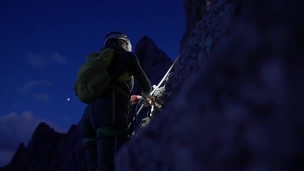 ドロミテの登山ルートでヘッドライトとクライミングギアを持つ女性登山家 イタリアアルプス — ストック動画