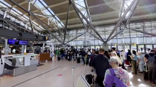 手荷物が落下し セキュリティを通過するのを待って空港に並んでいる人々 乗客は彼らのフライトを逃す可能性があり 予約を変更するのは面倒です — ストック動画