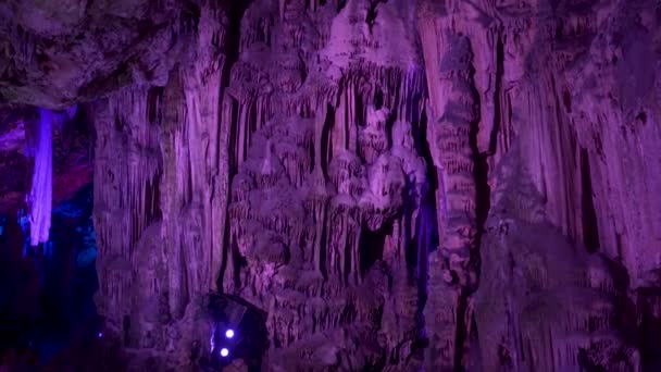セント マイケルズ洞窟の巨大な鍾乳石は紫色の光に照らされています — ストック動画