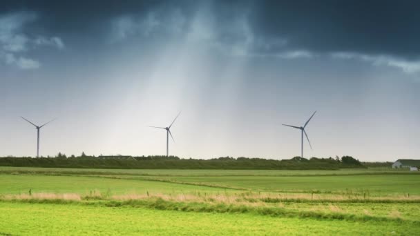 Turbine Eoliche Sul Campo Verde Lussureggiante Nuvole Buie Tempestose Raggi — Video Stock