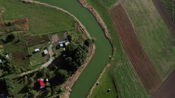 Luftaufnahme Eines Ruhigen Kurvenreichen Flusses Zwischen Den Feldern Und Höfen — Stockvideo