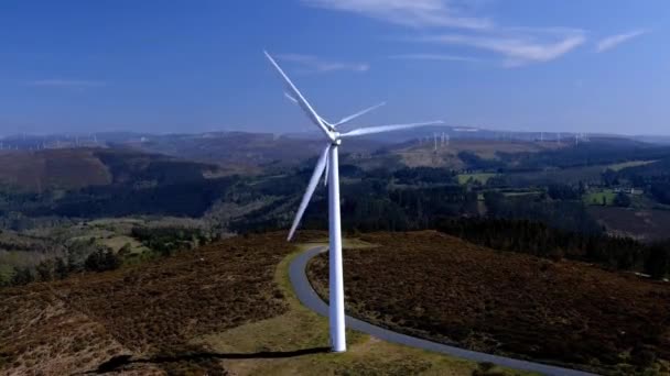 Two Wind Turbines Lined Spinning Blades Mountains Small Green Forests — Vídeo de stock