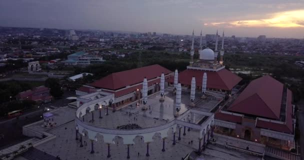 静かな時間に中央ジャワの偉大なモスク Majt のスライディングドローンショット 太陽はオレンジ色で 天気は曇っている いくつかの柱といくつかの傘が閉じられています — ストック動画