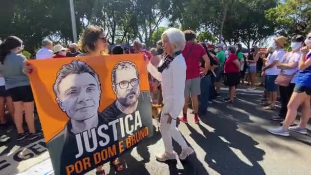 照片上有两个女人 两个女人带着围裙 照片上有两个男人在亚玛森被杀 还有一群人在巴西利亚参加抗议活动 — 图库视频影像