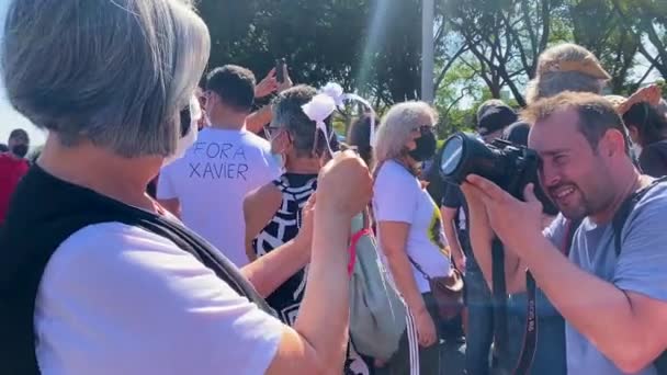 Una Mujer Sosteniendo Dos Flores Blancas Con Cintas Protesta Contra — Vídeo de stock