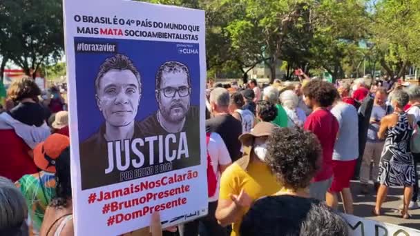 ブラジルでの殺人に抗議して殺人されたブルーノ ペレイラとドム フィリップスの写真が入ったプラカードを持っています — ストック動画